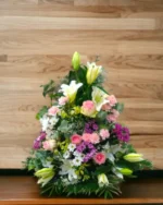 Centro de flores para funeral en tonos rosa y blanco